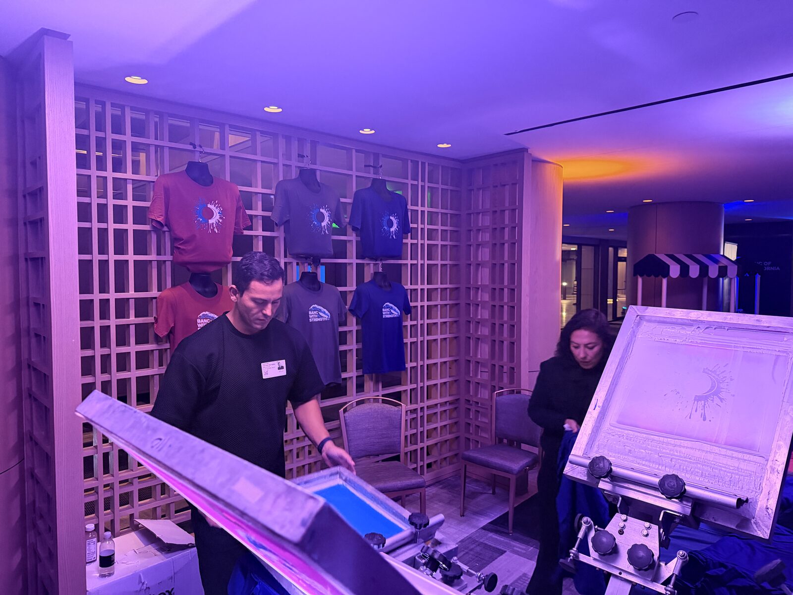 Wall of custom event shirts produced at a corporate activation