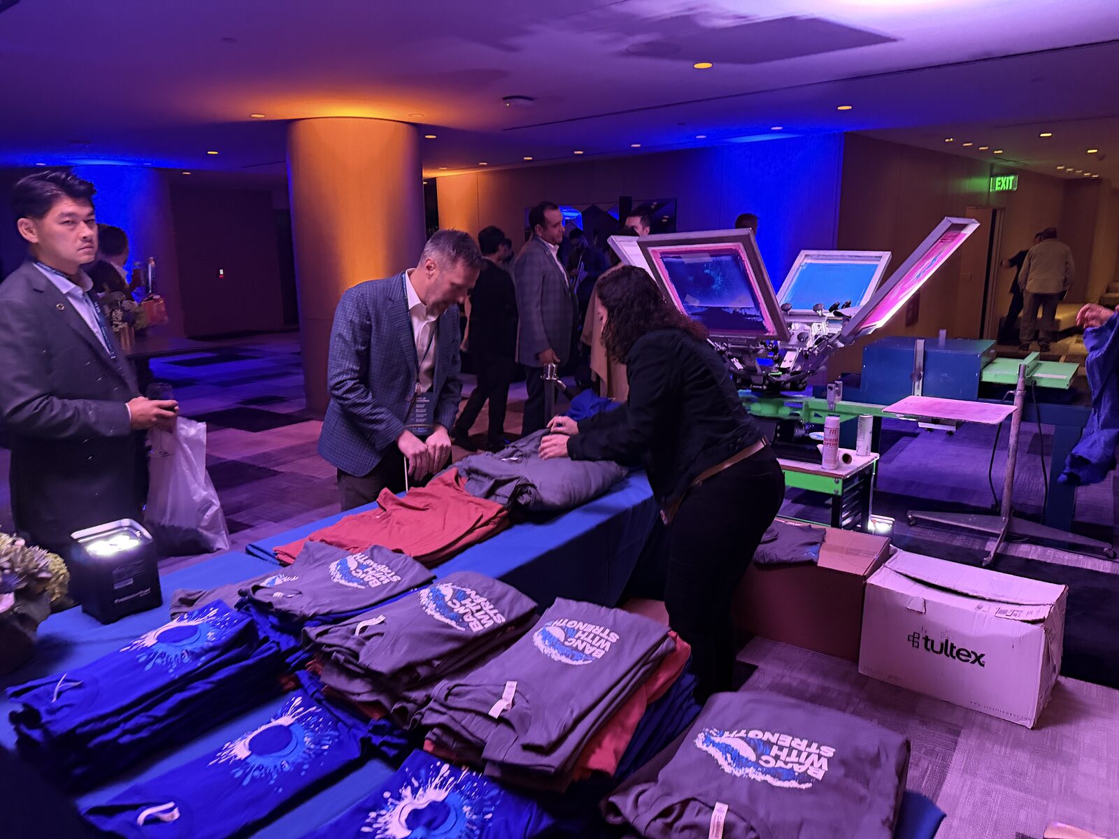 Folded custom apparel on a merch table at an executive summit