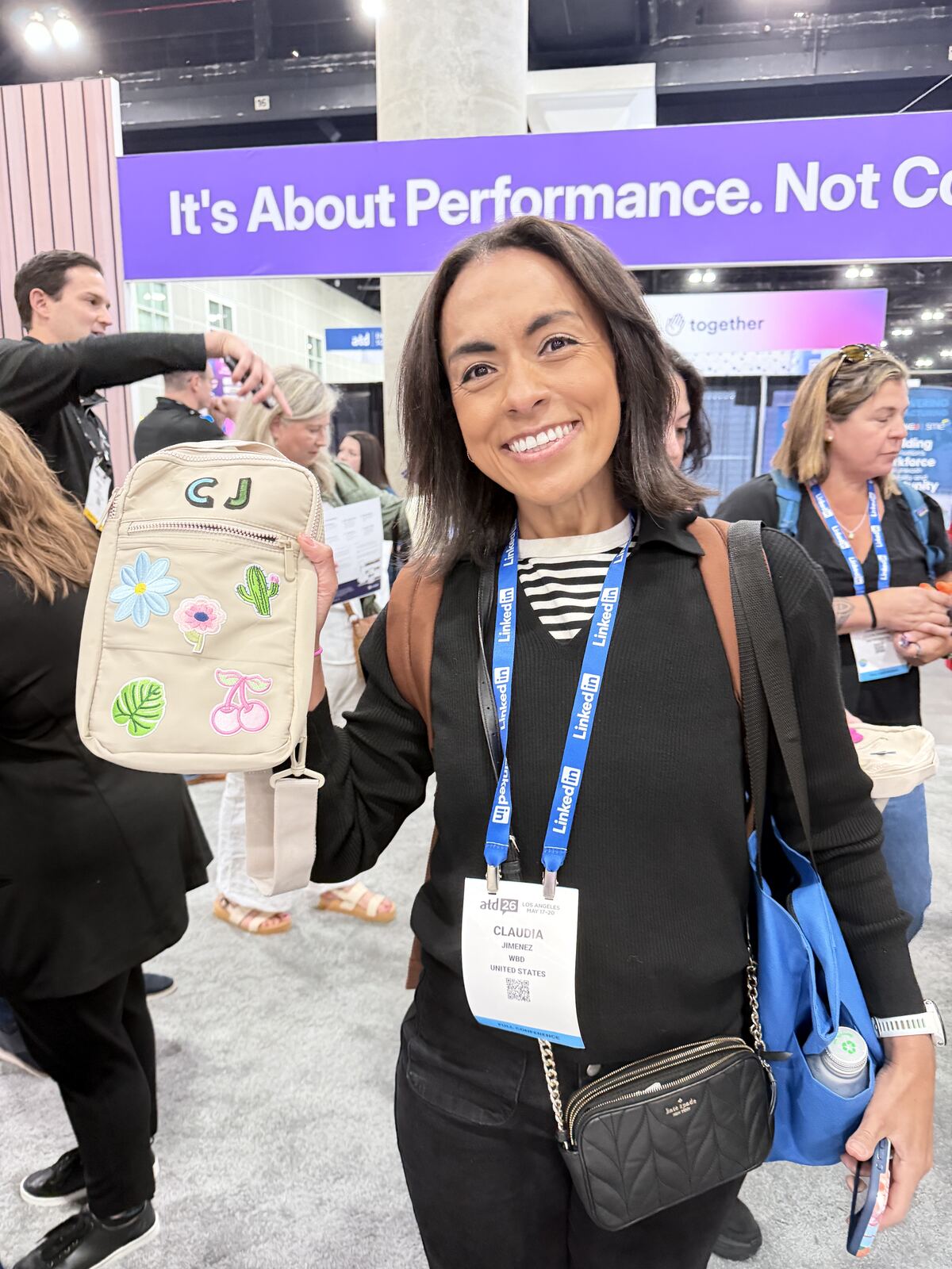 Staff member demonstrating screen-pressed products to visitors at an indoor corporate event booth